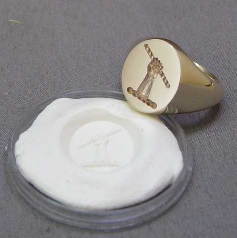 Hand holding scroll crest engraved signet ring